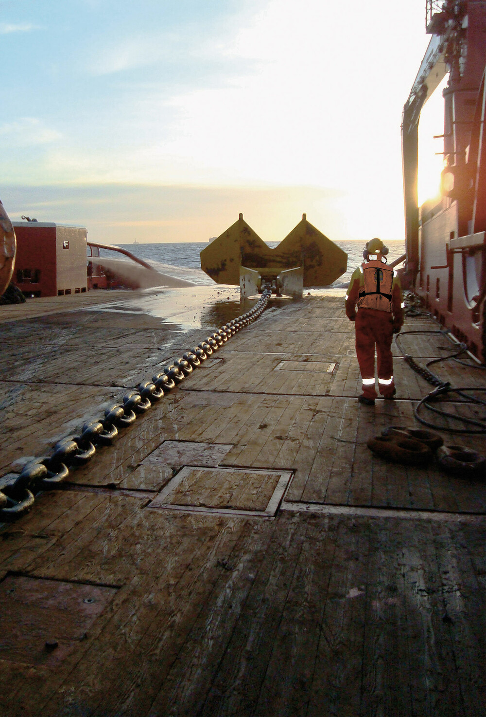 Matros på dekk på et offshorefartøy med anker klar til å senkes.