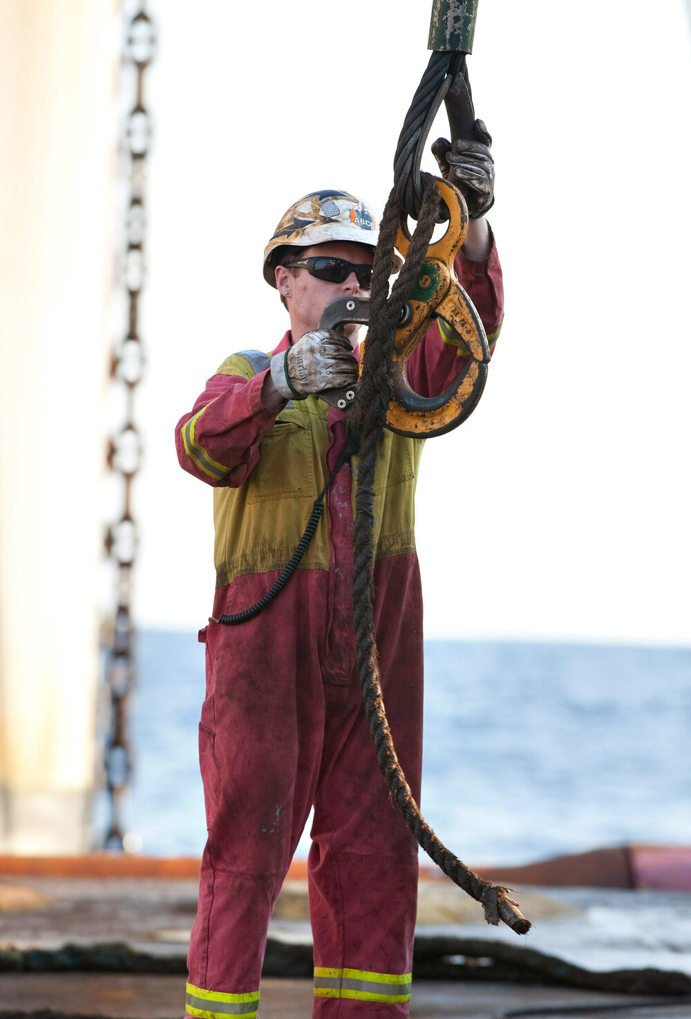 Matros på et offshorefartøy klargjør heisekrok på dekk.