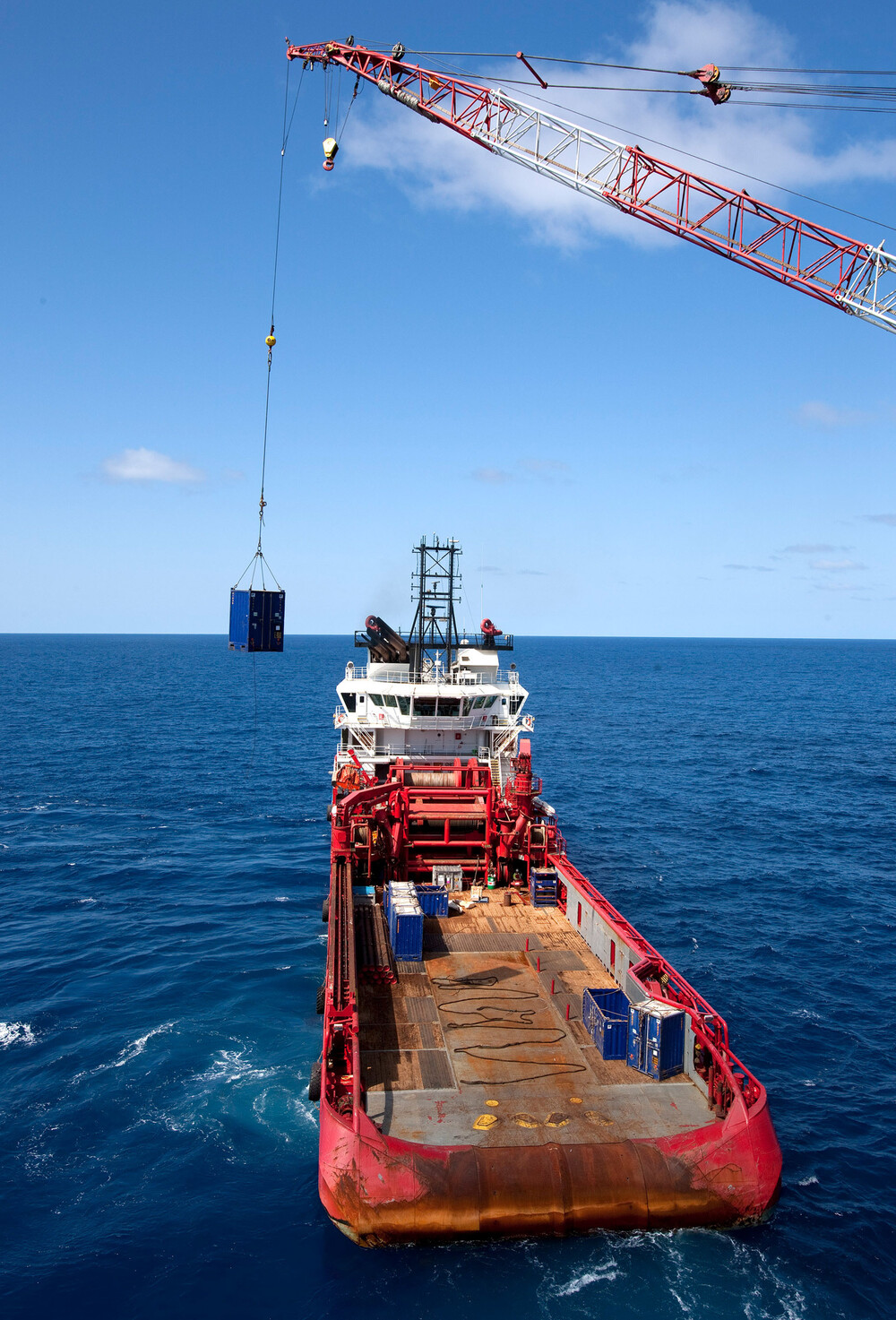 Et offshorefartøy leverer utstyr til en borerigg langt ut på havet.